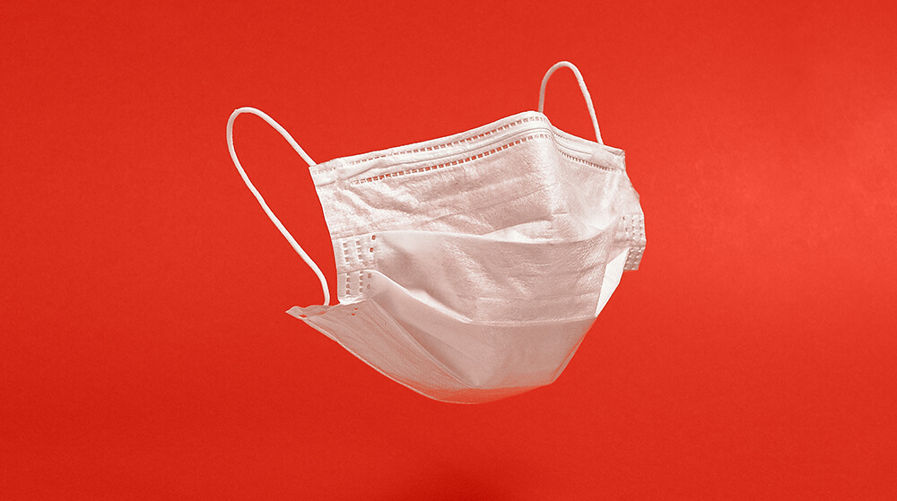 Surgical face mask on red background. Minimal medical concept. Medical equipment