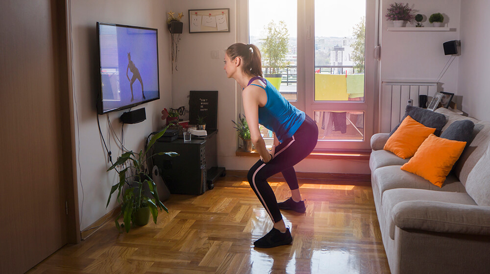 Woman exercising and watching online fitness live streaming classes