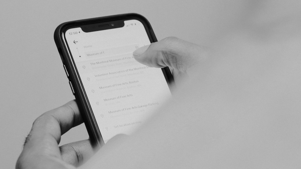 Black and white depiction of a person scrolling on a smartphone.